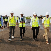 Leite caminhando acompanhado de quatro pessoas enquanto vistoria obras na pista do aeroporto Salgado Filho.